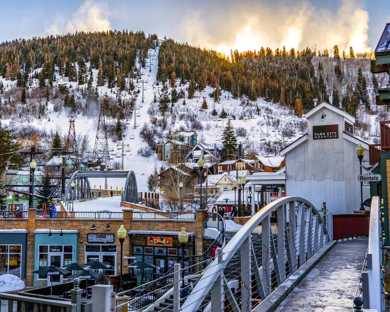 downtown village of a ski resort in colorado with restaurants, a bridge, and a lift hill