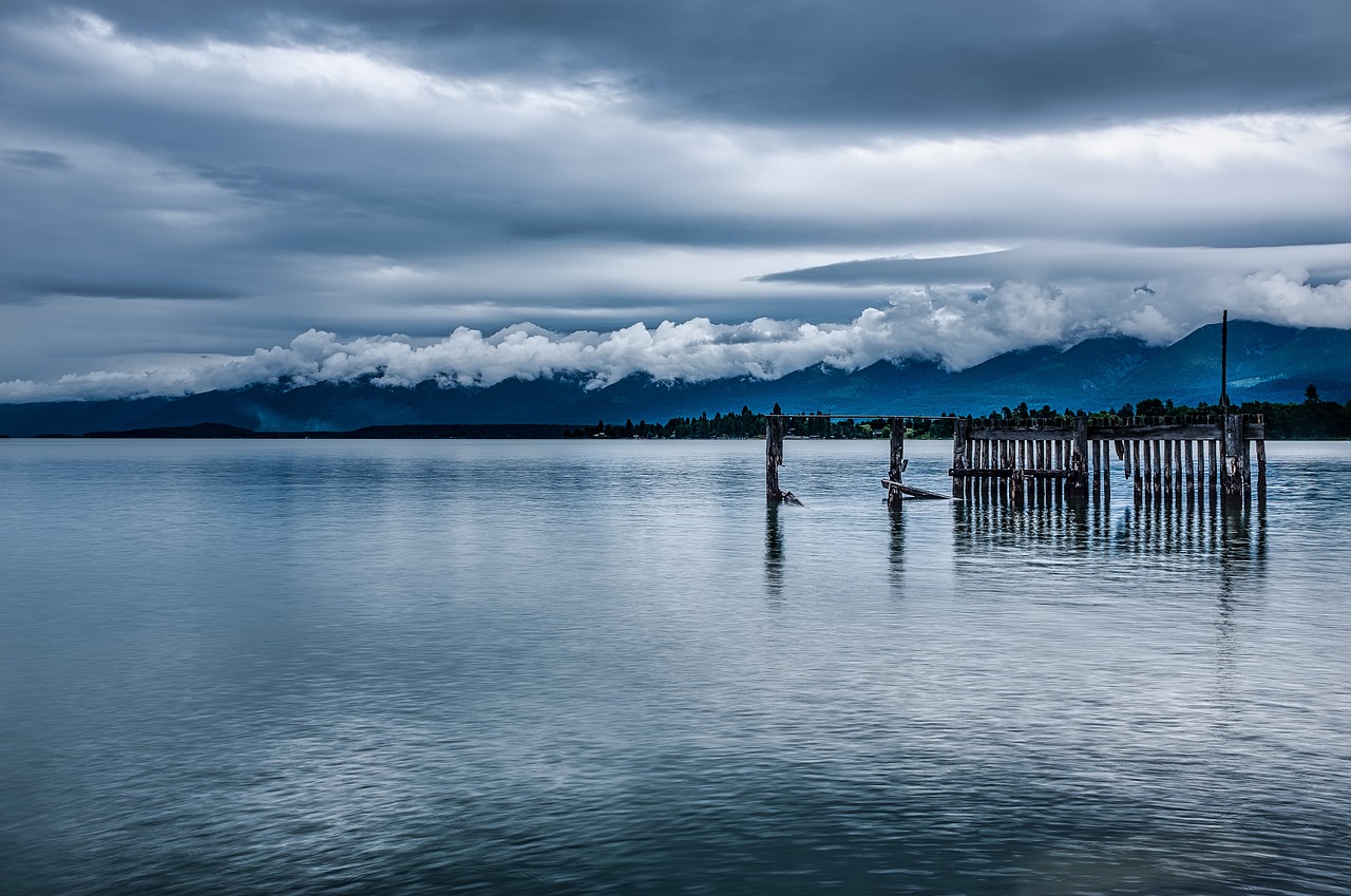 flathead lake with mountains and clouds - yellowstone to glacier national park