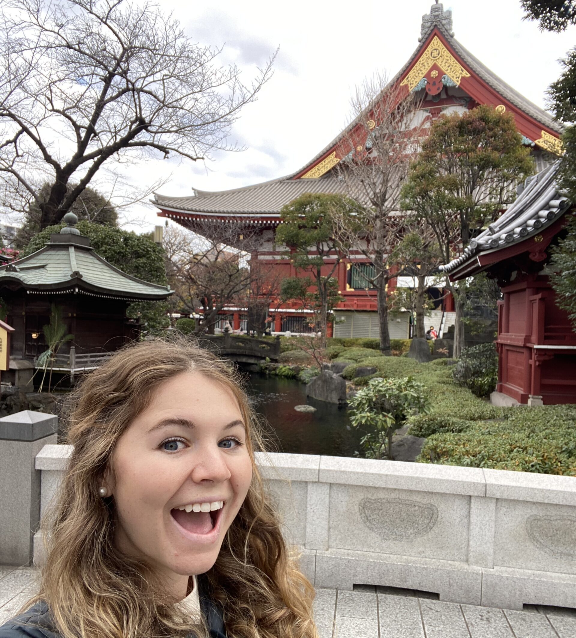 solo female traveler taking a selfie with japanese temple