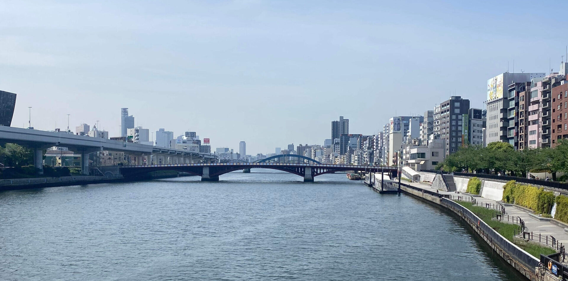 river with a walkway and bridge in tokyo