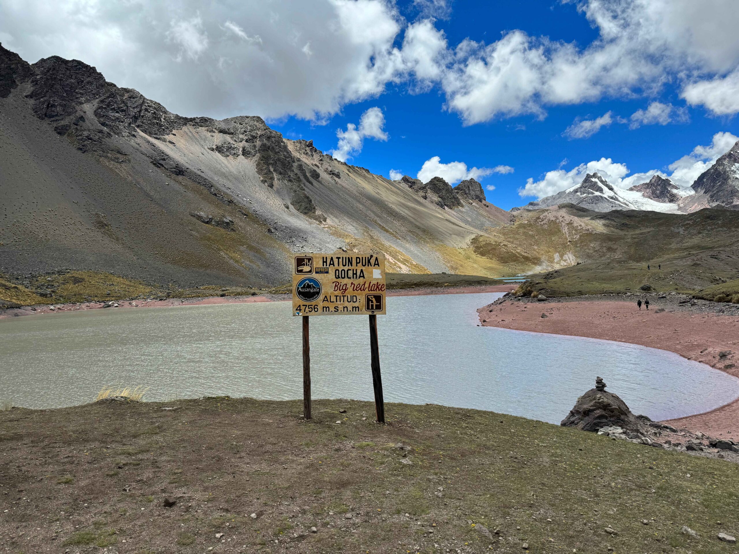 7 lakes of ausangate altitude sign with lake and mountains in background