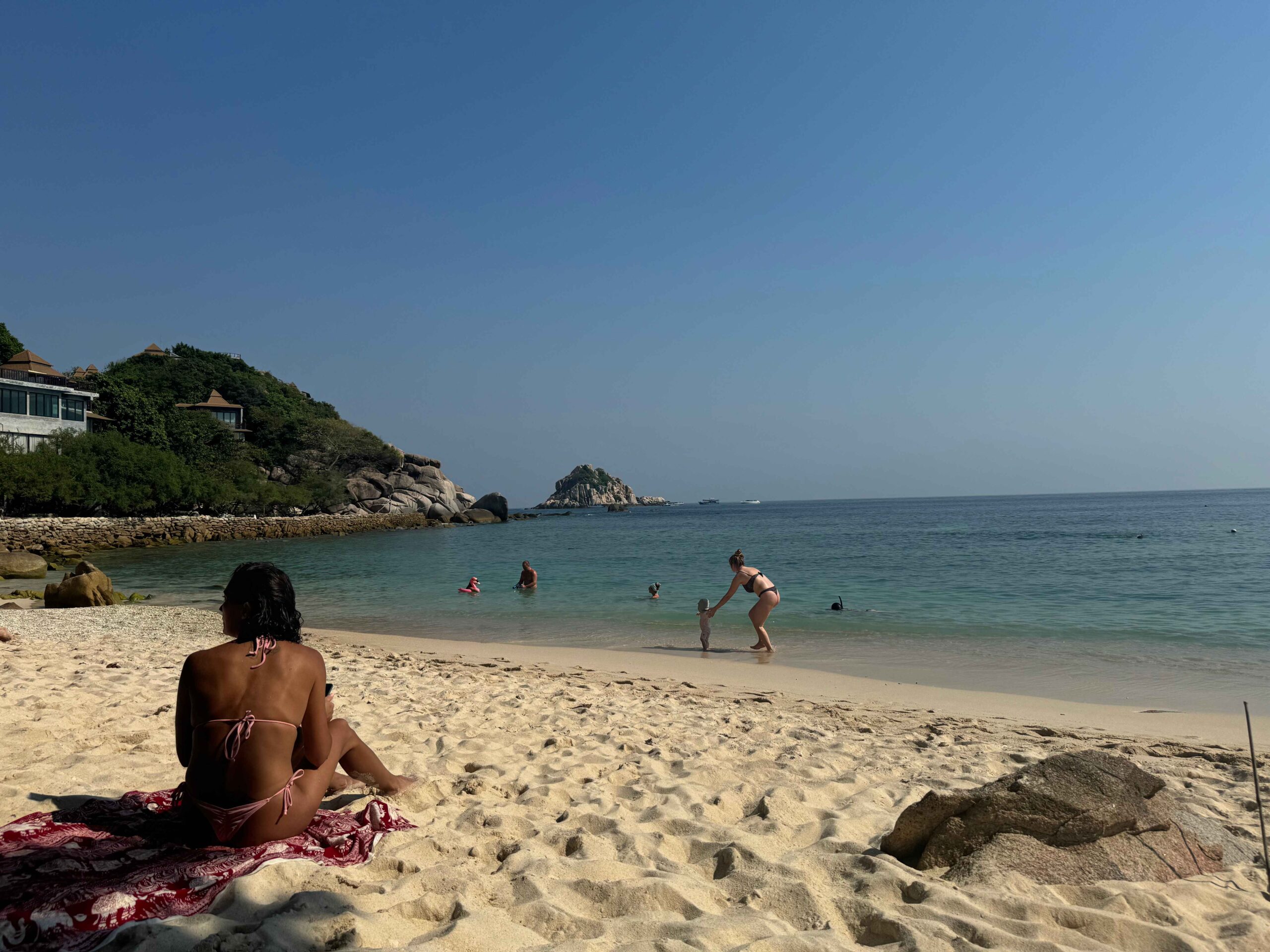 Sai Daeng Beach with white sand, blue water, and people playing