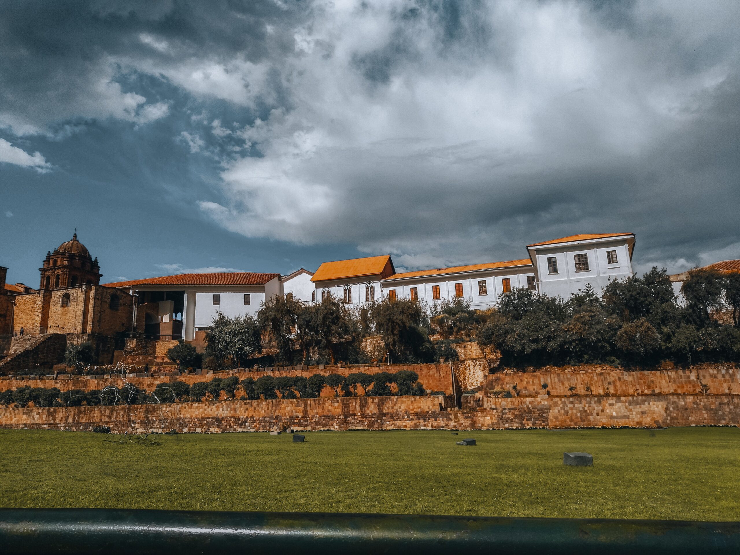 temple of the sun exterior and courtyard with big green field - 1 day in cusco itinerary