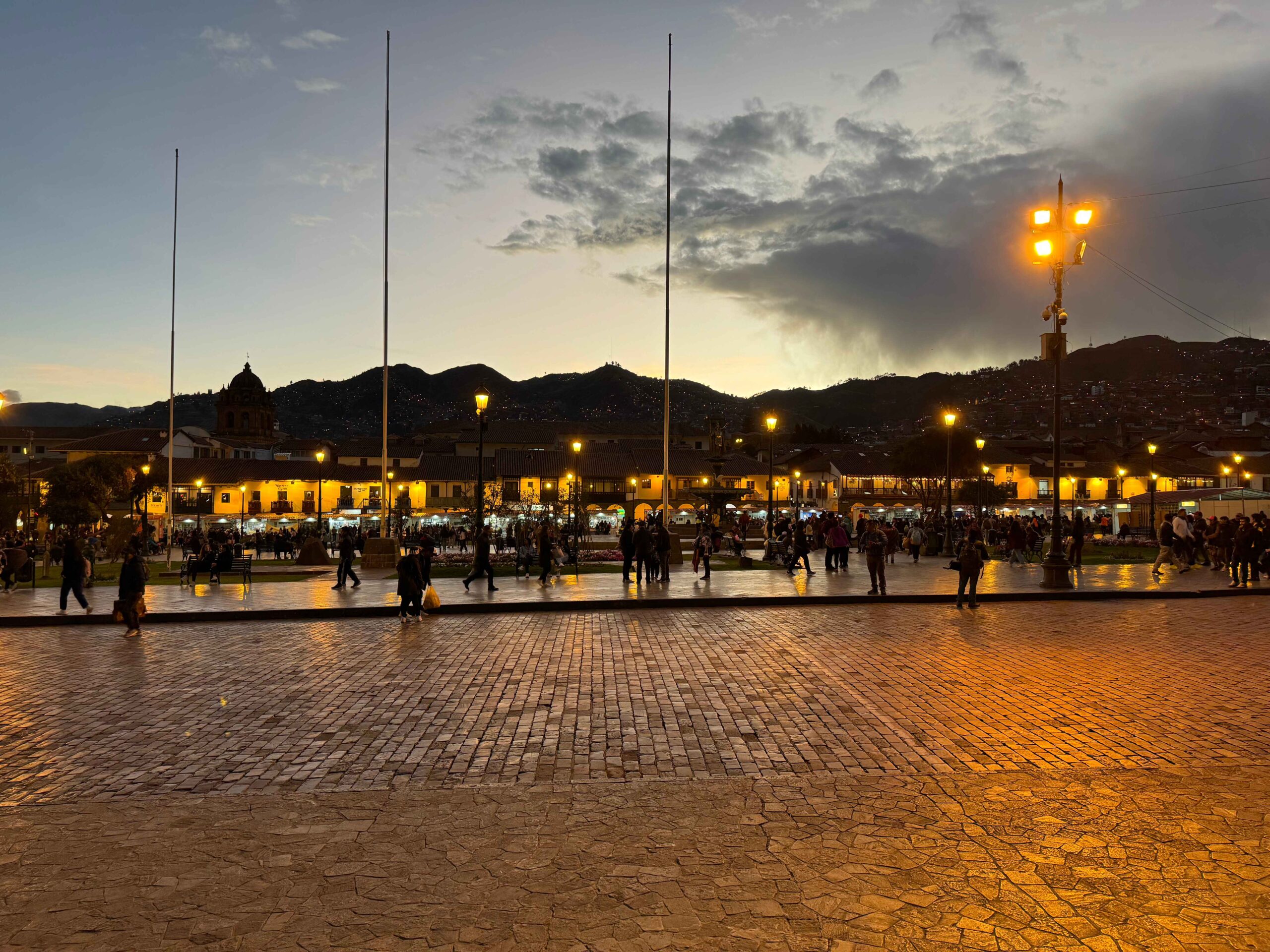 city plaza at night with streelights and mountains in the background