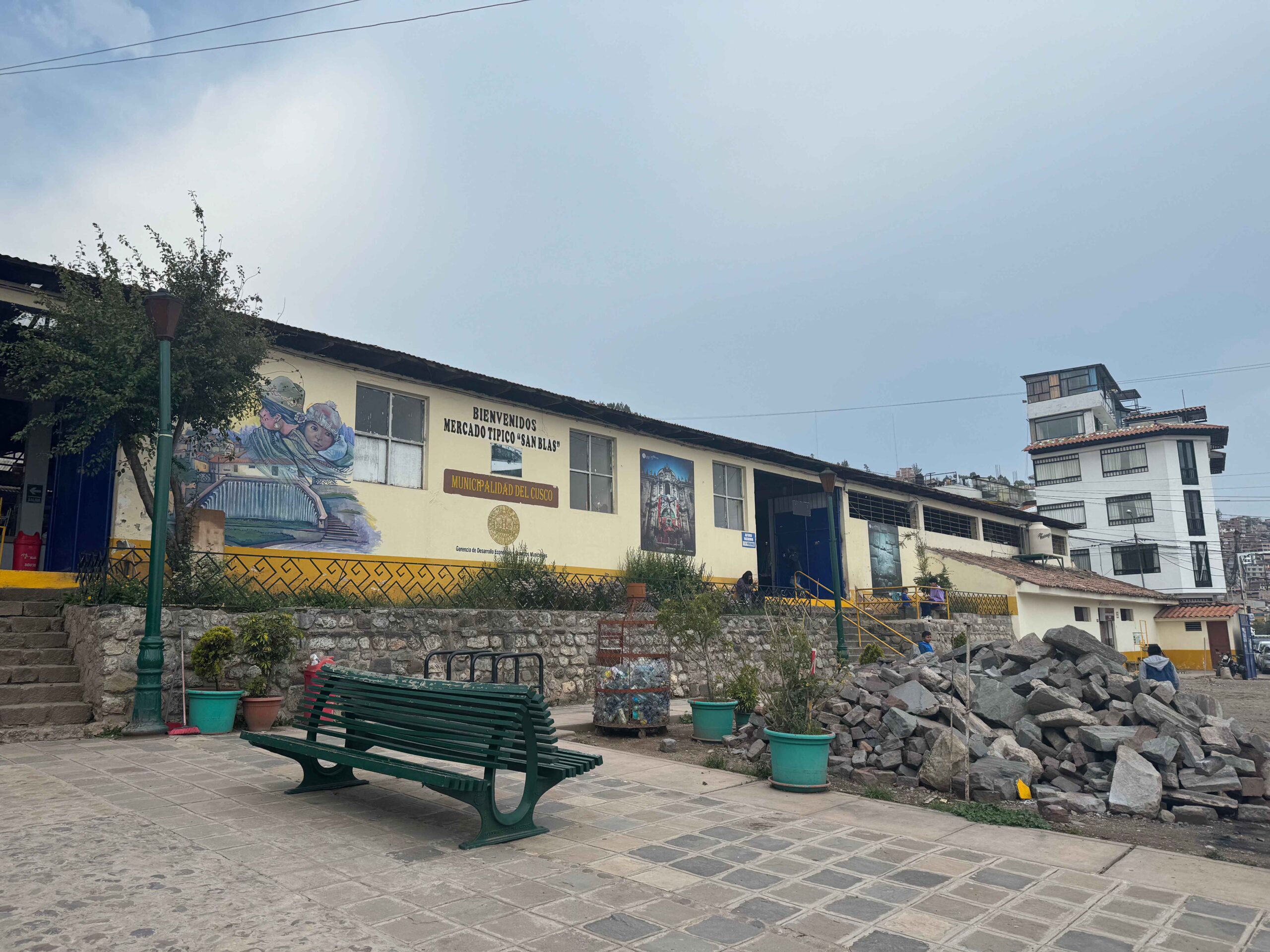 exterior of san blas market with cobblestone streets and yellow building - 1 day in cusco itinerary