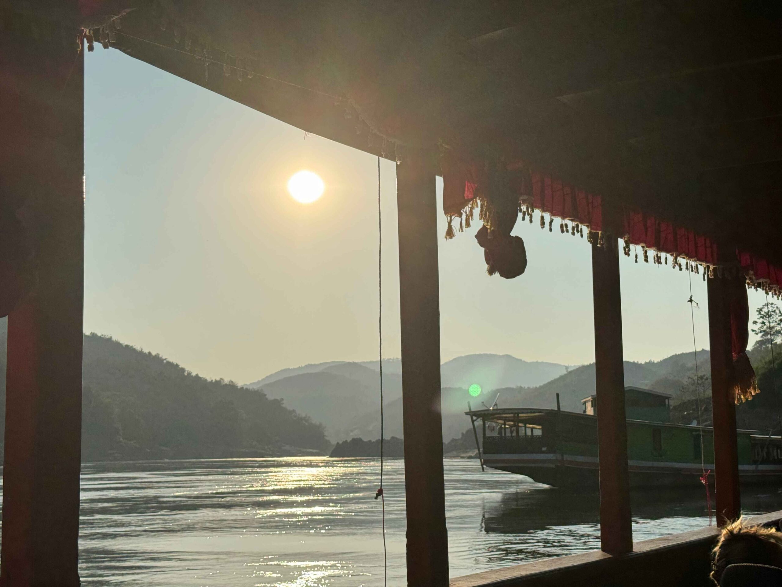 slow boat to luang prabang views from the boat on the water with mountains