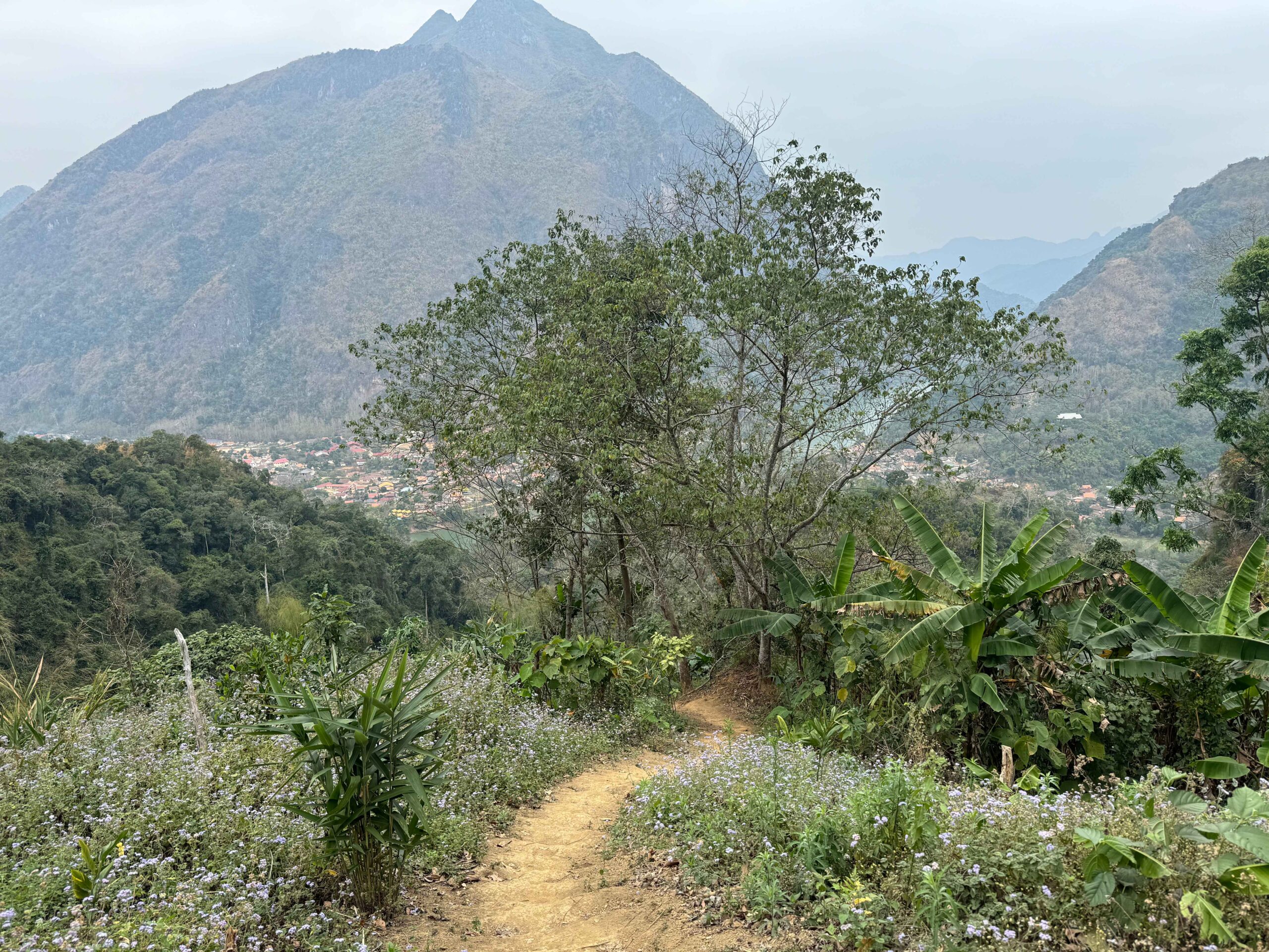 trail on a mountain with a view of nong khiaw village